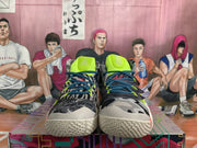 Front view of the pair showing patterned uppers, dark blue laces, neon accents, and textured cream-colored soles.