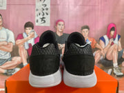 Rear view of black sneakers showing the heel panels and white soles.