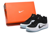 Black and white Nike sneakers displayed beside an orange Nike shoebox.