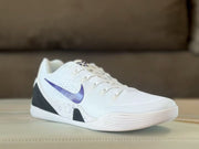 Angled front view showing the white upper, purple Swoosh and sculpted white sole of the Nike Kobe 9 sneakers.