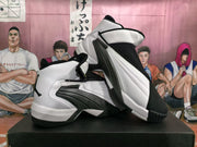 Angled view of the paired white and black sneakers showing the high-top shape, black overlays, and contrasting outsole.