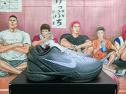Side profile of a black and gray basketball sneaker showing the textured upper, white Swoosh, and speckled sole.