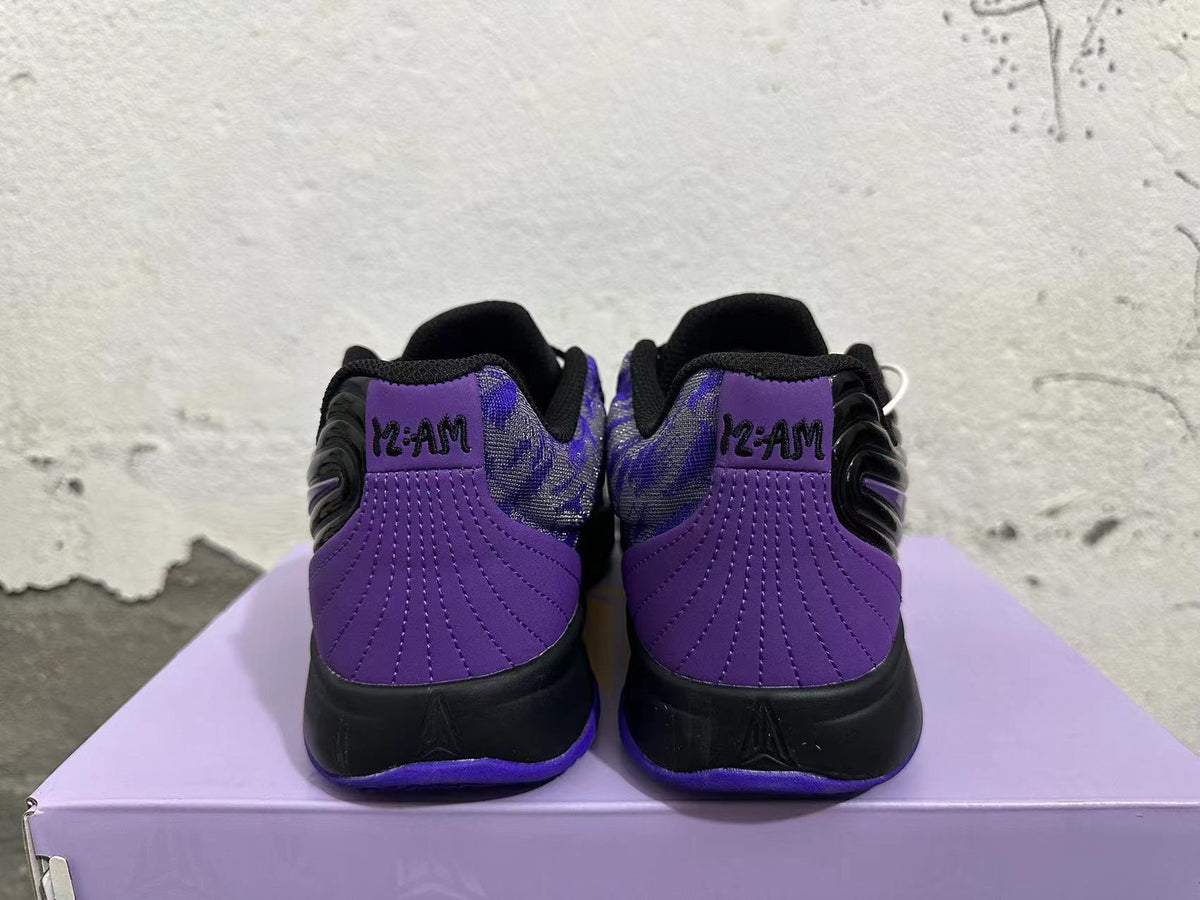 Rear view of black and purple Nike basketball shoes with patterned collars and purple heel panels.