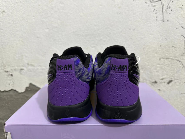 Rear view of black and purple Nike basketball shoes with patterned collars and purple heel panels.