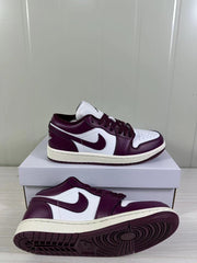 Side and outsole view of the low-top sneakers, showing the burgundy rubber tread and light midsole.
