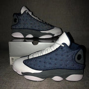 Air Jordan 13 Flint sneakers photographed under flash beside a shoebox.