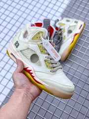 Front three-quarter view showing the off-white toe, gray laces, side panels, and attached tag.