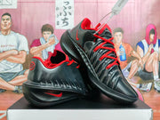Angled view showing black Nike basketball shoes with red accents, Swoosh details, and sculpted sidewalls.