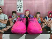 Front view of pink Nike GT Cut basketball shoes with purple tongues and yellow accents.