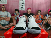 Front view of white Nike sneakers showing black toe caps, black graphic details, white laces, and ribbed white outsoles.