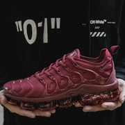 Side view of burgundy Nike sneakers with molded side cage details and a translucent segmented sole.