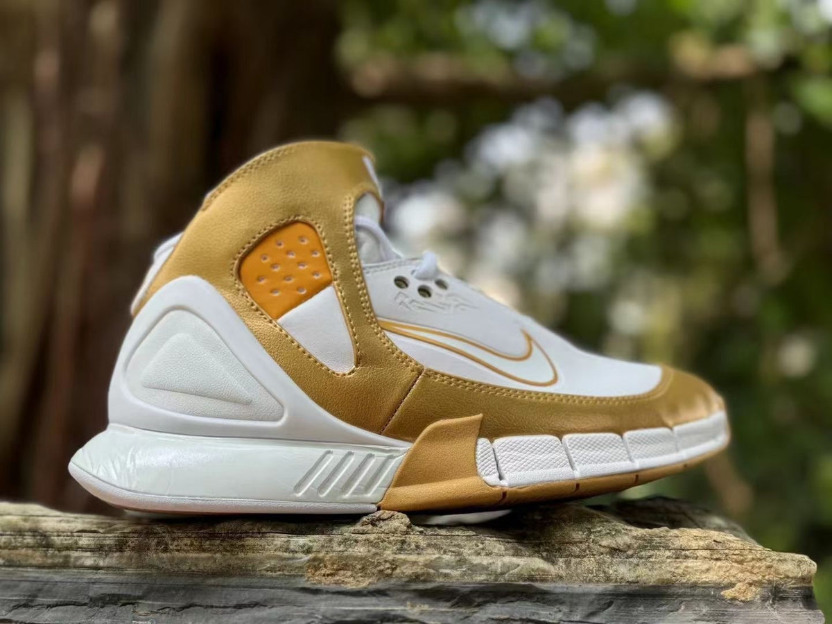 Side view of a white and gold Nike Kobe 2K5 high-top sneaker
