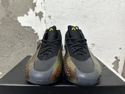 Front view showing black laces, gray toe overlays, bronze-toned side panels, and lime-green tongue details.