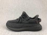 Side profile of the black lace-up sneaker showing the textured upper and ribbed outsole.