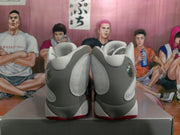 Rear view of white and gray high-top Jordan sneakers showing padded collars, layered heel panels, and red outsole accents.