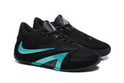 Angled view of the black and green low-top basketball shoes