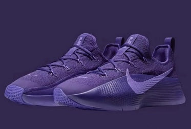 Pair of purple low-top lace-up sneakers shown against a dark purple background.