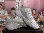 Angled view of the white and grey Jordan sneakers showing the lace-up construction, padded collar, and outsole shape.