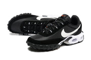 Pair of black Nike sneakers with white Swoosh panels, orange tongue accents and lugged soles.