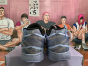 Rear view of blue-gray Nike sneakers showing padded collars, patterned uppers, and light-gray heel sections.