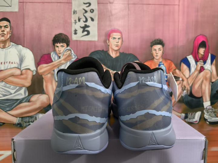 Rear view of blue-gray Nike sneakers showing padded collars, patterned uppers, and light-gray heel sections.
