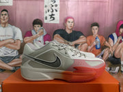 Side view of a gray and red Nike basketball sneaker showing the black Swoosh and textured outsole.