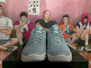 Front view of gray and blue Nike basketball sneakers with textured uppers and light-colored soles.