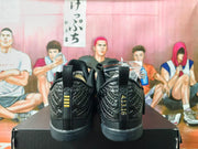 Rear view of black basketball shoes showing heel panels and Kobe Bryant details.