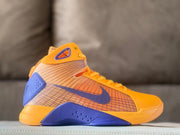 Side view of a gold-yellow and purple Nike Kobe high-top basketball shoe