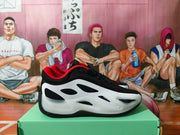 Side profile of a black and white Jordan basketball shoe with red collar lining