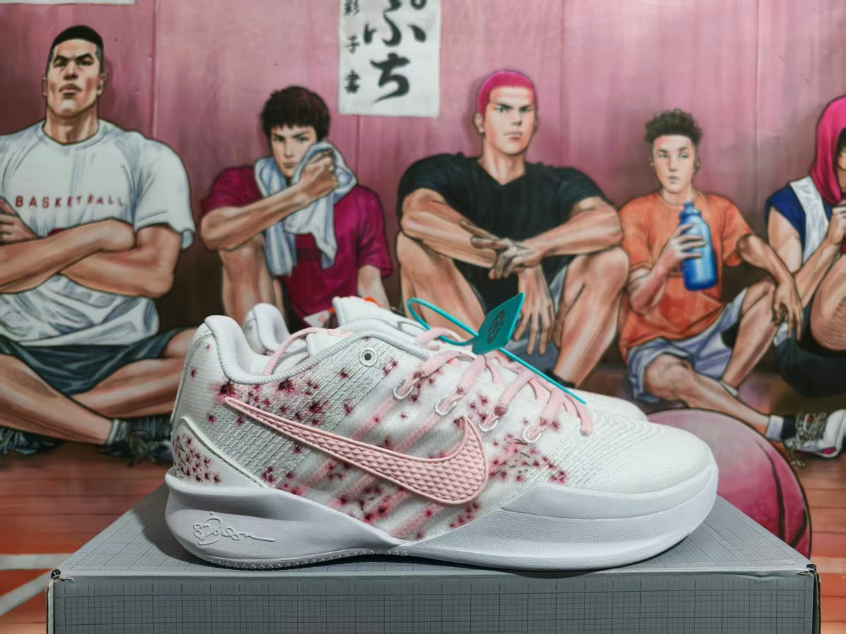 Side view of white Nike basketball shoes with pink accents and burgundy speckled panels