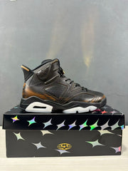 Side profile of the black Jordan Air Jordan 6 sneaker with bronze-toned heel detailing and a contrasting outsole.