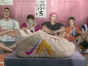 Side profile of a pink and white sneaker showing the layered side lettering and contrasting swoosh.