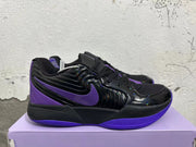 Side view showing a purple Nike Swoosh, glossy black overlay, and sculpted sole.