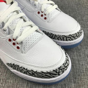 Close-up of the white perforated toe and lacing area with red eyelets and grey-and-black elephant-print trim.