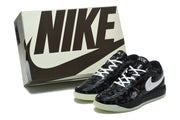 Black and white sneakers displayed beside a Nike-branded shoe box.