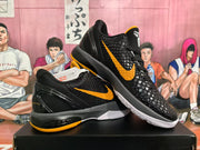 Angled view of two black and yellow basketball sneakers displaying the textured uppers, yellow side marks and contrasting outsoles.
