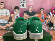 Rear view of green Jordan low-top sneakers showing embroidered heel logos, white midsoles, and light gum-colored outsoles.