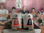 Rear view showing mismatched red and black heel panels with Nike branding on the white sneakers.