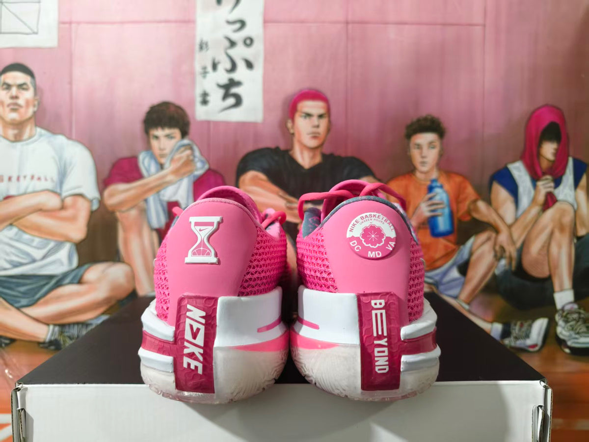 Rear view of pink and white Nike basketball sneakers showing heel graphics, pink mesh panels, and white heel sections.