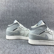 Pair of high-top sneakers shown from the side against a grey fabric background.