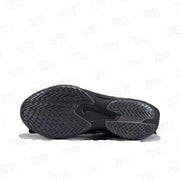 Underside view of a black basketball shoe showing the directional textured outsole and central Swoosh detail.
