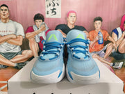 Front view of sky-blue basketball sneakers with dark blue laces and lime tongue details.