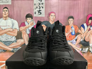 Front view of all-black lace-up high-top sneakers with tongue logos and perforated outsole details.