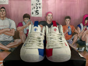 Front view of the mismatched pair showing white uppers with blue details on one shoe and red details on the other.