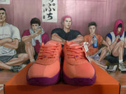 Front view showing the pink lace-up Nike basketball sneakers, perforated toe panels, and purple outsoles.