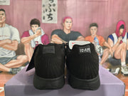 Rear view of the black sneakers showing matching “12:AM” heel tabs and black stitched heel panels.