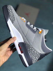 Side view of a grey sneaker with elephant-print heel detailing and a white midsole