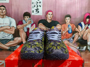 Front view showing the pair's lavender laces, purple-and-yellow graphic uppers, and dark textured toe outsoles.