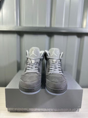 Front view of a pair of grey high-top sneakers with white laces, padded collars, and translucent blue outsole edges.
